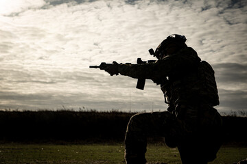 silhouette of a man pointing a rifle