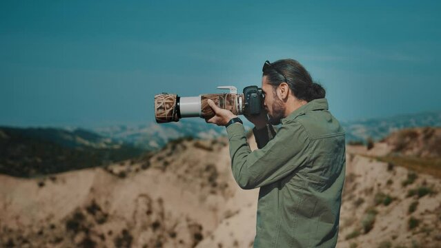 Wildlife photographer tourist taking pictures in wild desert nature.