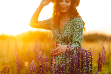 Lavender purple flowers beautiful sunshine blooming in a garden.  Young woman walking in summer...