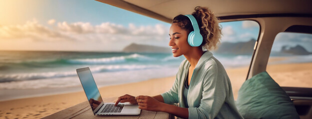 Fototapeta premium Young woman works on laptop in van with ocean view, embodying remote work freedom. Headphones on, she enjoys serene beach ambiance while fulfilling digital tasks.