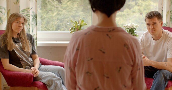 Couple man and woman engage in family psychotherapy during a counseling session with a psychologist. Couple discuss their relationship dynamics, emotional challenges. People talking about problems.
