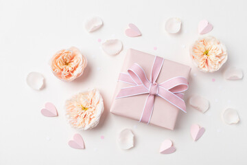 Birthday, Woman or Mothers Day greeting card. Pink hearts, rose flowers and gift box on pastel table top view. Flat lay. - 781382417