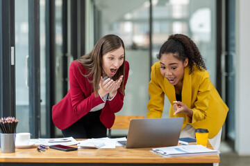 A businesswoman in a yellow blazer engaging in a productive discussion with a colleague in a red...