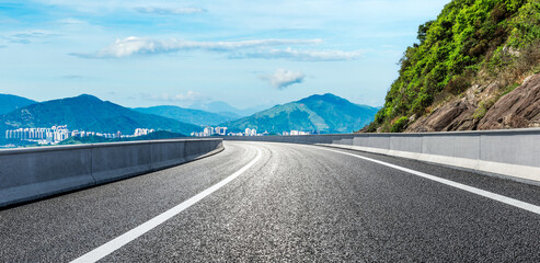 Asphalt highway road and green mountains with sky clouds background. panoramic view.