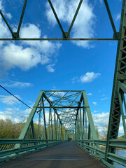 Bridge over the river. Structure of a metal bridge in the city with a blue sky.