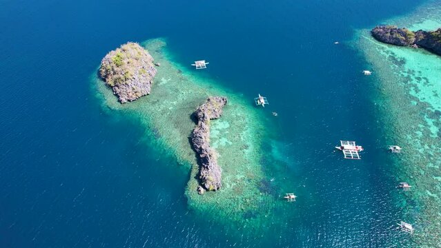 4K Aerial drone video of Siete Pecados Siete with boats surrounded by blue sea. Coron, Palawan. Philippines.
