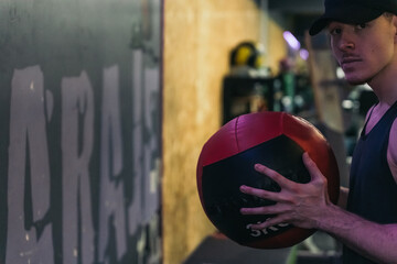 A serious redhead athlete holds a weight ball, ready to throw.