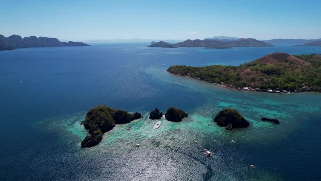 4K Aerial drone video of Siete Pecados Siete with boats surrounded by blue sea. Coron, Palawan. Philippines.