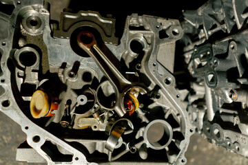 in the service station there is piston and other disassembled parts from the car on the head of the crankshaft