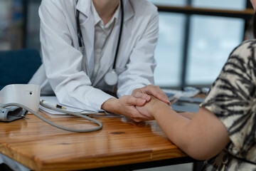 A female doctor showing empathy and comfort to her patient during a consultation in a medical...