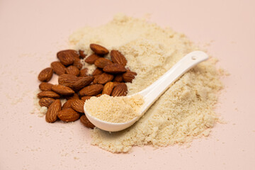 Almond flour and almonds on a beige background