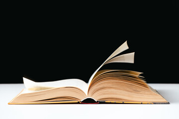 Pages of a thick book are turned on a white and black background, space for text.
