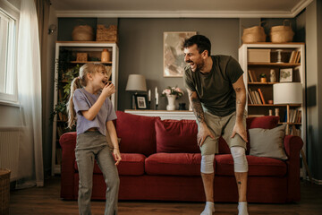 Dad and daughter engaged in a home workout routine amidst stylish decor