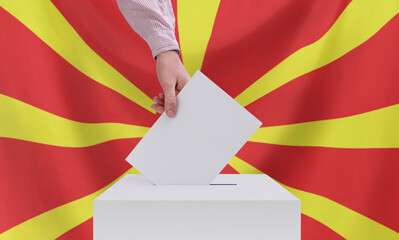 Elections, North Macedonia. A hand throws a ballot into the ballot box. The flag of North Macedonia...