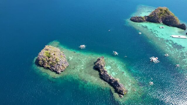 4K Aerial drone video of Siete Pecados Siete with boats surrounded by blue sea. Coron, Palawan. Philippines.