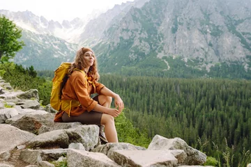 Poster Woman traveler enjoying beautiful view of mountains. Beautiful mountains landscape view. Lifestyle, adventure, nature, active life. © maxbelchenko