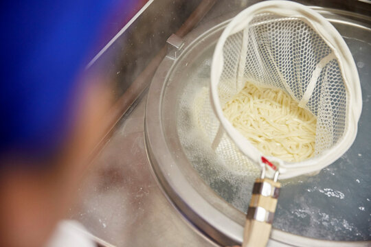 Udon noodles being cooked in boiling water