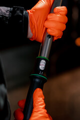 close-up At service station in the hands of a car repairman device for tightening bolts in the...
