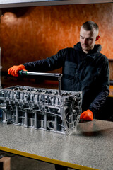 At a service station in the hands of a master a device for tightening bolts works with bolts on the...