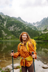 Woman tourist traveler walking  along hiking trails in the mountains among forests and cliffs. Beautiful mountains landscape view. Lifestyle, adventure, nature, active life.