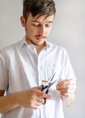 Man cutting a Cigarette with Scissors