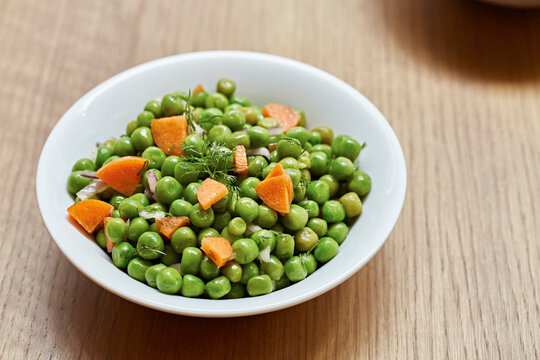 A salad of peas, carrots, red onion and fresh dill