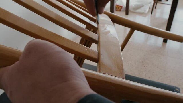 Restoration of a wooden chair. Close-up. Vintage things. Using sandpaper to restore old wooden furniture slow motion.