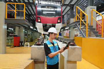 Electric train engineer employees are maintenance technicians, wearing uniforms and helmets,...