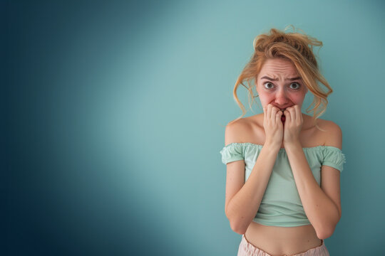 Femme anxieuse se rongeant les ongles sur un fond bleu, espace pour texte