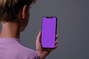 App mockup shoulder view of a boy holding an smartphone with an entirely purple screen