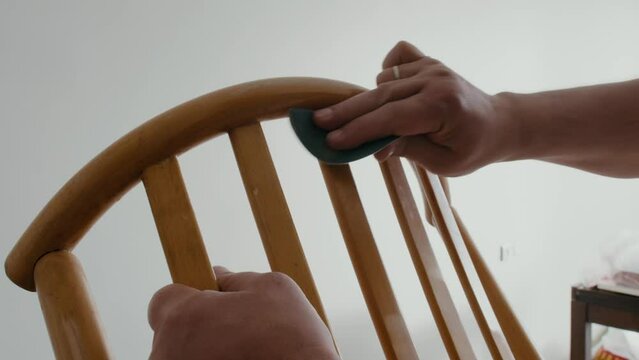 Restoration of a wooden chair. Close-up. Vintage things. Using sandpaper to restore old wooden furniture slow motion.