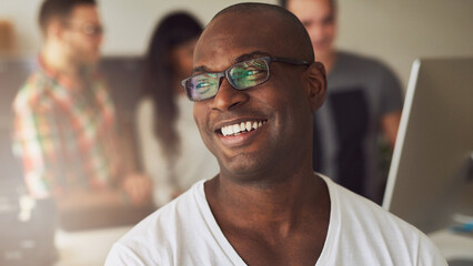 Happy African American businessman, with black glasses smiling in the office while his diverse...