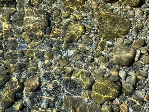 Pebbles and stones in transparent water.