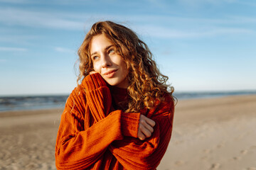 Outdoor portrait of pretty  woman on the beach  in cold sunny weather.  Travel, fashion, blogging concept.