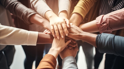 Overhead view of a diverse group of people stacking hands together. Teamwork and unity concept. Design for corporate team-building or community collaboration themes