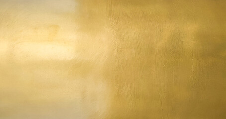 Gold wall texture background. Yellow shiny gold foil paper sheet surface, vibrant golden luxury...