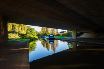 Grand Union Canal under the bridge of dural carriageway on sunny day in Milton Keynes - obrazy, fototapety, plakaty
