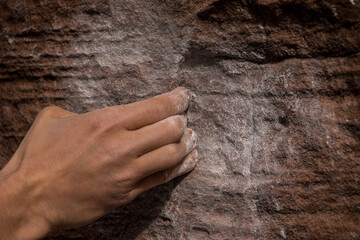 Details of a climber's hand while scaling a rock face