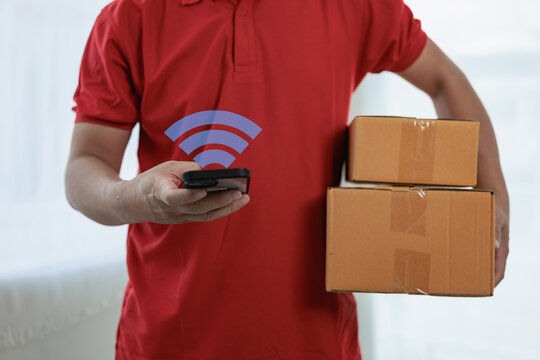 A person wearing a red T-shirt is delivering a package to a satisfied customer. friendly staff High quality courier service with cardboard boxes delivering parcels to customers. Courier delivers parce