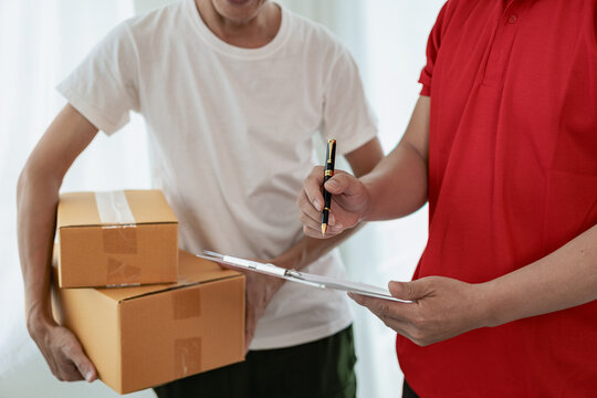 A person wearing a red T-shirt is delivering a package to a satisfied customer. friendly staff High quality courier service with cardboard boxes delivering parcels to customers. Courier delivers parce