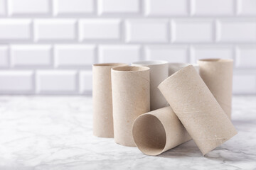 Empty toilet paper roll. Empty toilet paper rolls on marble background. Paper tube of toilet paper. Place for text. Copy space. Flat lay. Eco-friendly reuse recycle