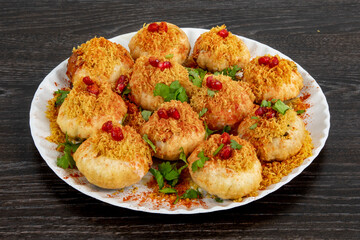 A plate of traditional Indian or Pakistani appetizer  Dahi Puri, crispy shells stuffed with boiled...