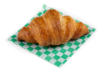 A French croissant pastry on a green checked paper isolated on white