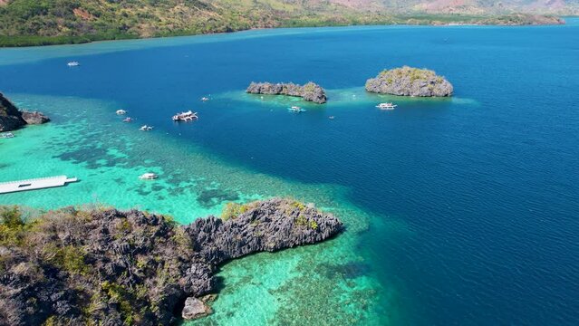 4K Aerial drone video of Siete Pecados Siete with boats surrounded by blue sea. Coron, Palawan. Philippines.
