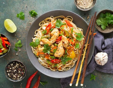 Spicy asian noodles with chicken and vegetables. top view