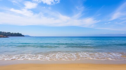 The ocean is calm and the sky is clear. The beach is empty and the water is a beautiful blue color