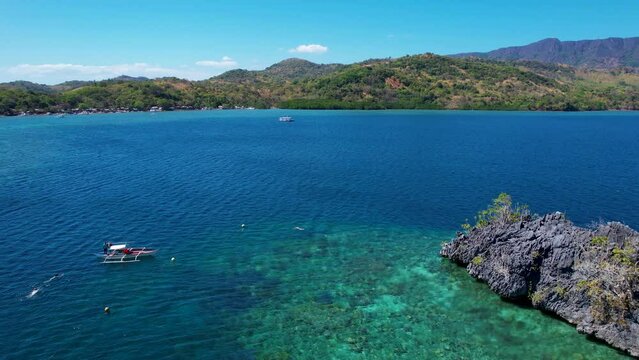 4K Aerial drone video of Siete Pecados Siete with boats surrounded by blue sea. Coron, Palawan. Philippines.