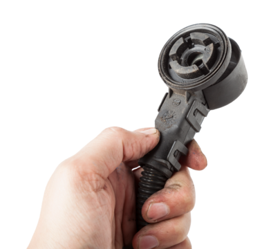 A car connector or trailer for closing an electrical circuit that a mechanic holds in gloves during repairs.