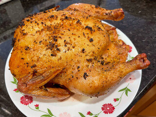 Smoked whole chicken on a white plate