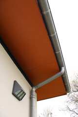 Gouttière aluminium gris sur la façade de la maison, descentes rondes et sous-face en panneau...